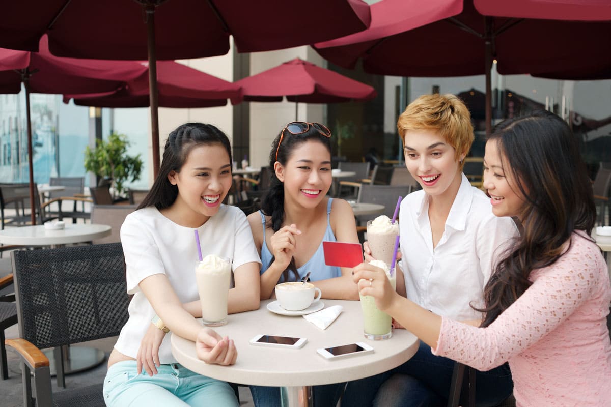 group of friends using gift card at cafe